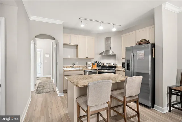 a kitchen with refrigerator a sink and chairs