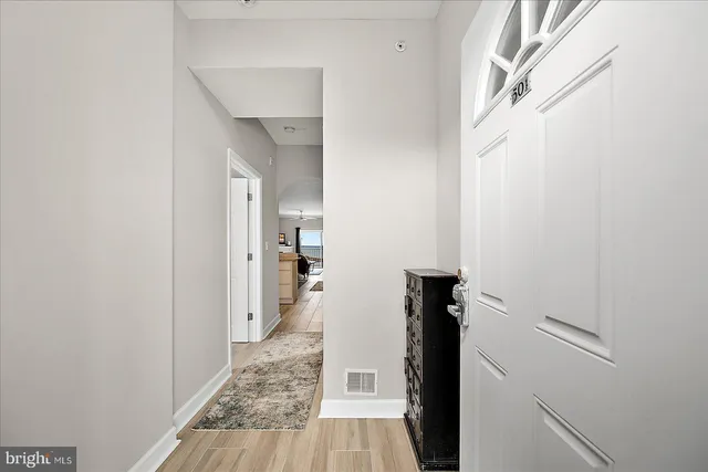 a view of a hallway with wooden floor and staircase
