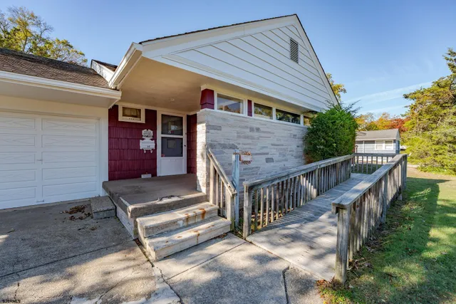 a view of house with wooden deck and furniture