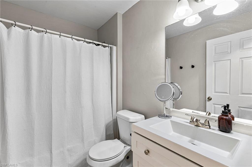 8264-8268 Matanzas Road Fort Myers, FL 33967 - Photo 12 of 33 a bathroom with a sink vanity mirror and toilet