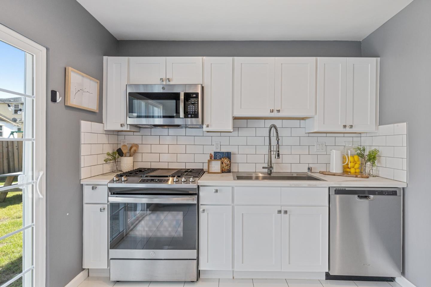 551 Inverness Drive Pacifica, CA 94044 - Photo 14 of 37 a kitchen with granite countertop white cabinets and stainless steel appliances