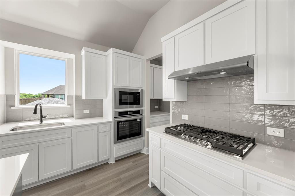 941 Gold Finch Lane Forney, TX 75126 - Photo 12 of 27 a kitchen with white cabinets and appliances