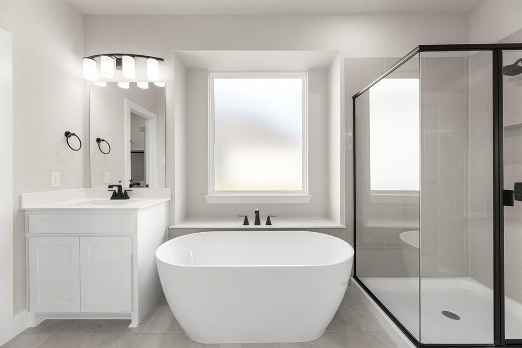 941 Gold Finch Lane Forney, TX 75126 - Photo 18 of 27 a bathroom with a bathtub a shower a sink and mirror