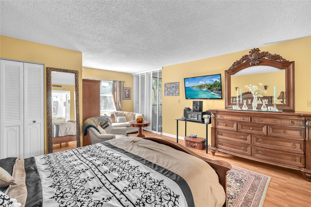 3910 Inverrary Boulevard, Unit 308B Lauderhill, FL 33319 - Photo 16 of 53 a bedroom with a bed and wooden floor