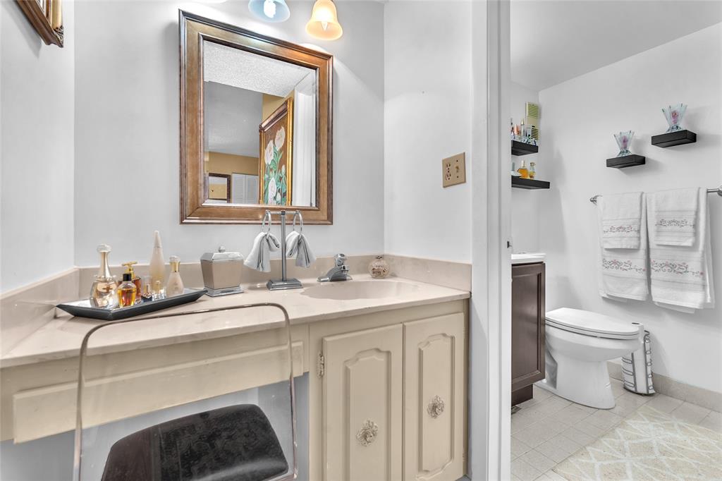 3910 Inverrary Boulevard, Unit 308B Lauderhill, FL 33319 - Photo 18 of 53 a bathroom with a toilet a sink and a mirror