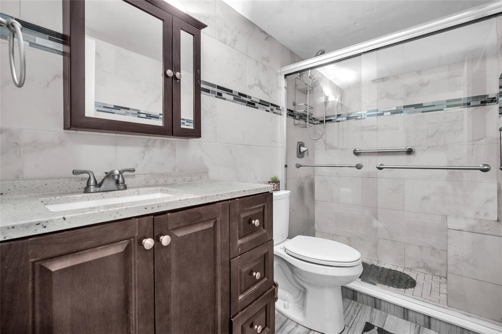 3910 Inverrary Boulevard, Unit 308B Lauderhill, FL 33319 - Photo 23 of 53 a bathroom with a granite countertop sink toilet and shower