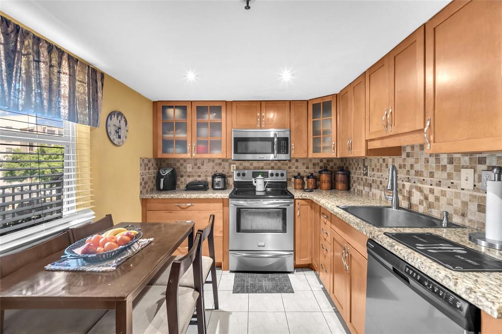 3910 Inverrary Boulevard, Unit 308B Lauderhill, FL 33319 - Photo 4 of 53 a kitchen with stainless steel appliances granite countertop a stove sink and cabinets