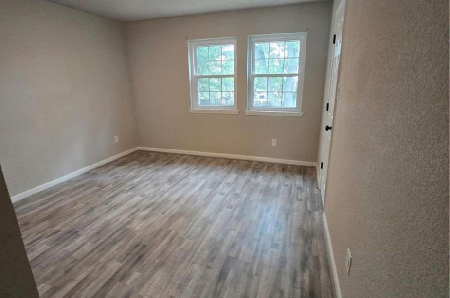 8351 Ariel Street Houston, TX 77074 - Photo 5 of 10 an empty room with wooden floor and windows