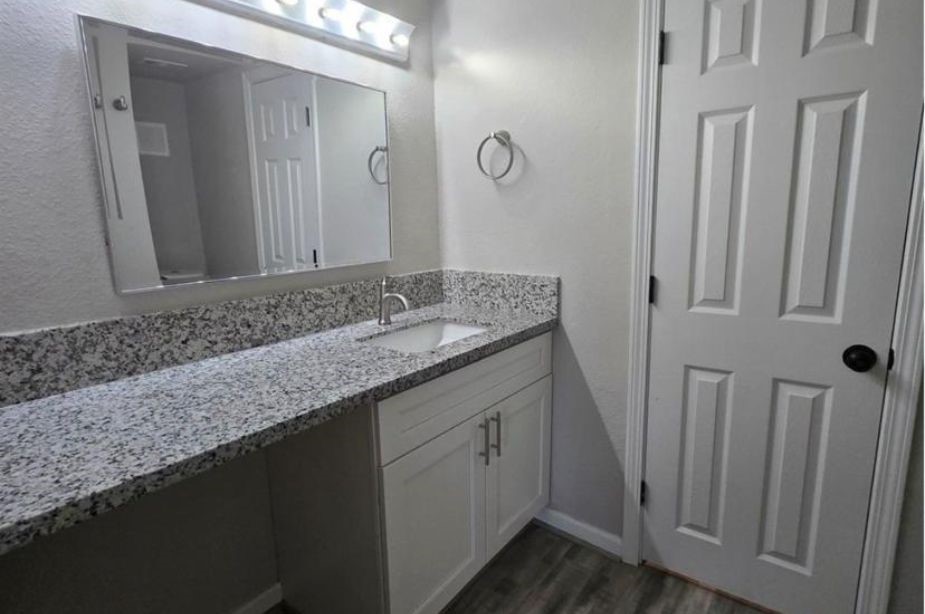 8351 Ariel Street Houston, TX 77074 - Photo 6 of 10 a bathroom with a granite countertop sink and a mirror