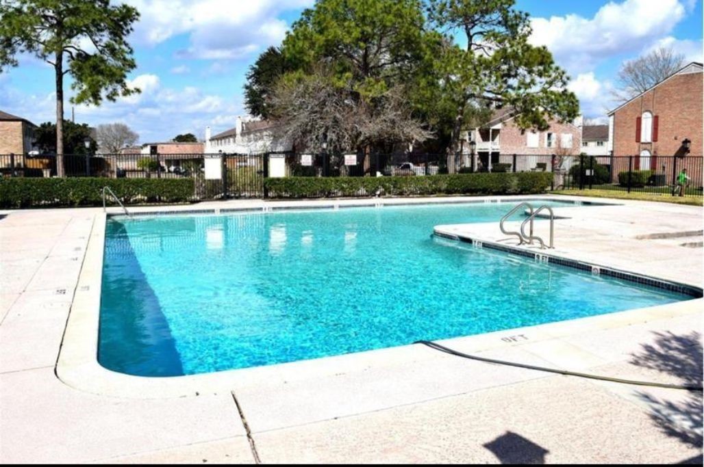 8351 Ariel Street Houston, TX 77074 - Photo 9 of 10 a view of a swimming pool in a yard with palm trees