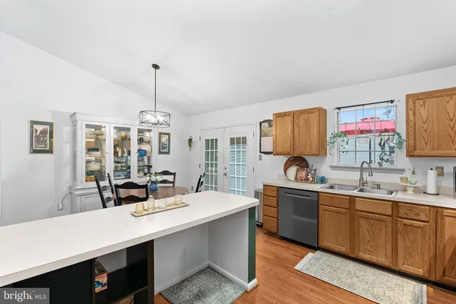 a view of a kitchen counter space a sink wooden floor and living room view