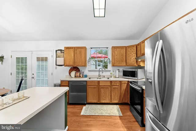 a kitchen with stainless steel appliances granite countertop a refrigerator sink and stove
