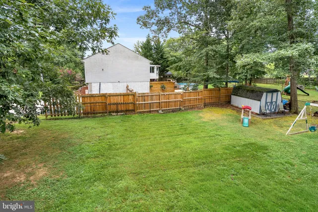 a front view of a house with a garden and trees