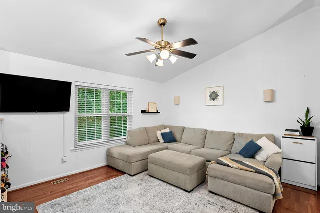 a living room with furniture tv and a window