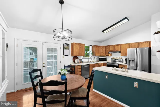 a dining room with furniture a chandelier and wooden floor