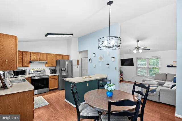 a view of a dining room with furniture a chandelier and wooden floor