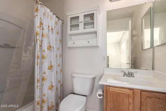 a bathroom with a granite countertop toilet a sink and a mirror