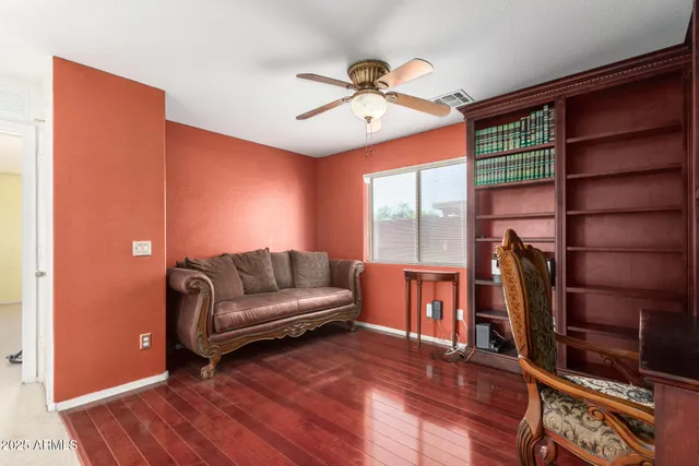 a living room with furniture a ceiling fan and a window