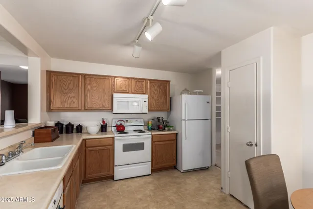 a kitchen with a sink a refrigerator and cabinets