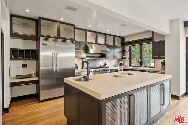 a kitchen with kitchen island a stove a sink and a refrigerator