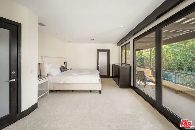 a spacious bedroom with a large bed and a large window