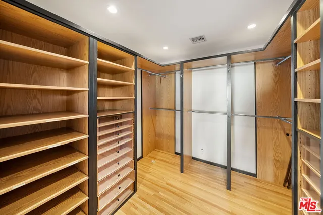 a view of walk in closet with wooden floor