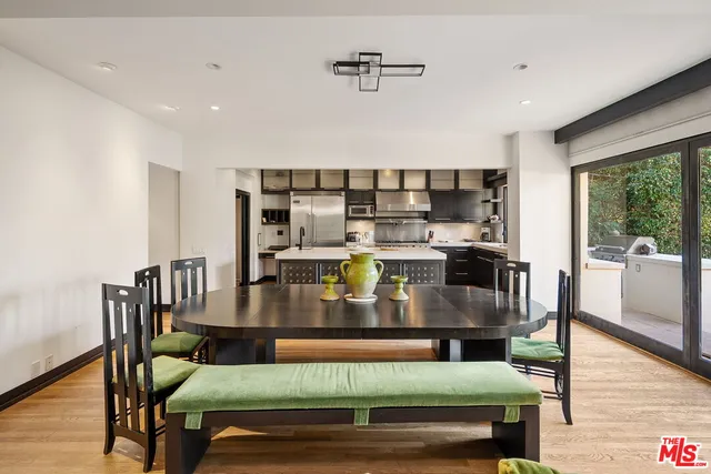 a living room with stainless steel appliances furniture a rug and a view of kitchen