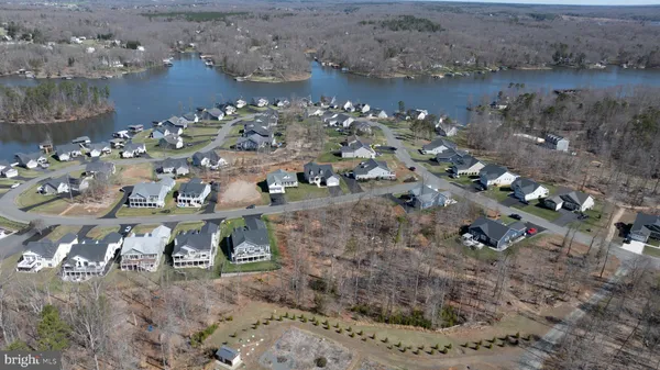 an aerial view of a house with a yard and large tree