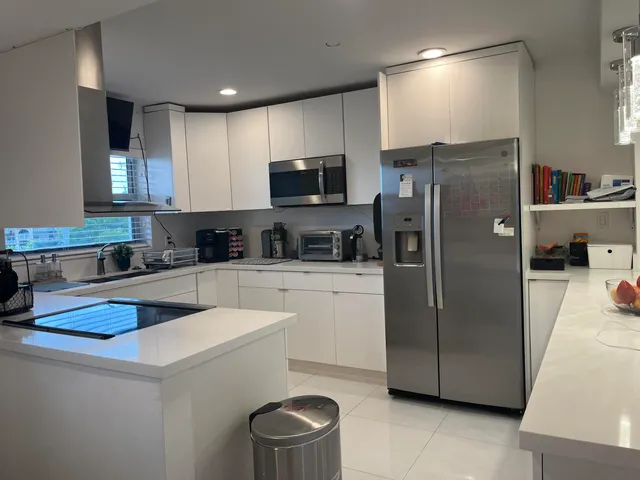a kitchen with a refrigerator a sink and cabinets