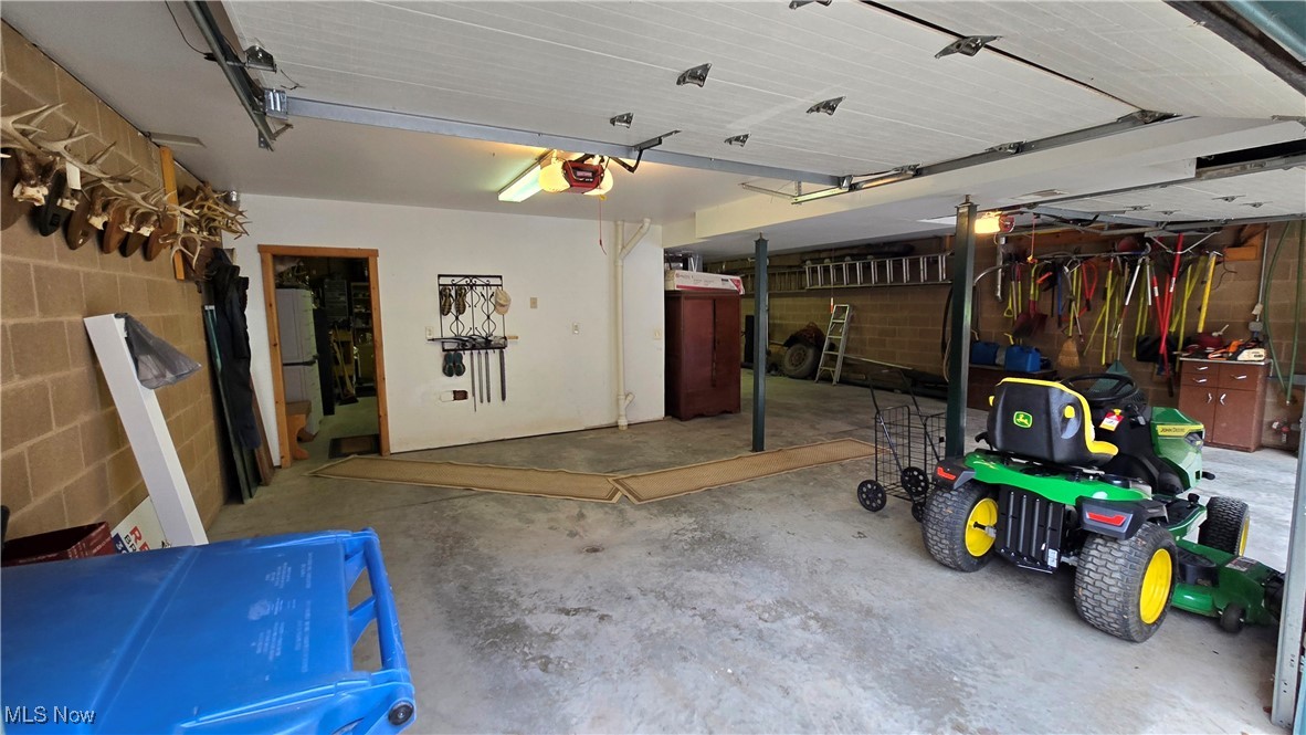 587 North Fork Road Wheeling, WV 26003 - Photo 27 of 35 Garage with a garage door opener, concrete block wall, and freestanding refrigerator