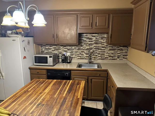 a kitchen with stainless steel appliances a stove a sink and a refrigerator