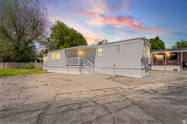24 Grover Street Layton, UT 84041 - Photo 1 of 21 White-sided residential structure with a covered porch and white railing