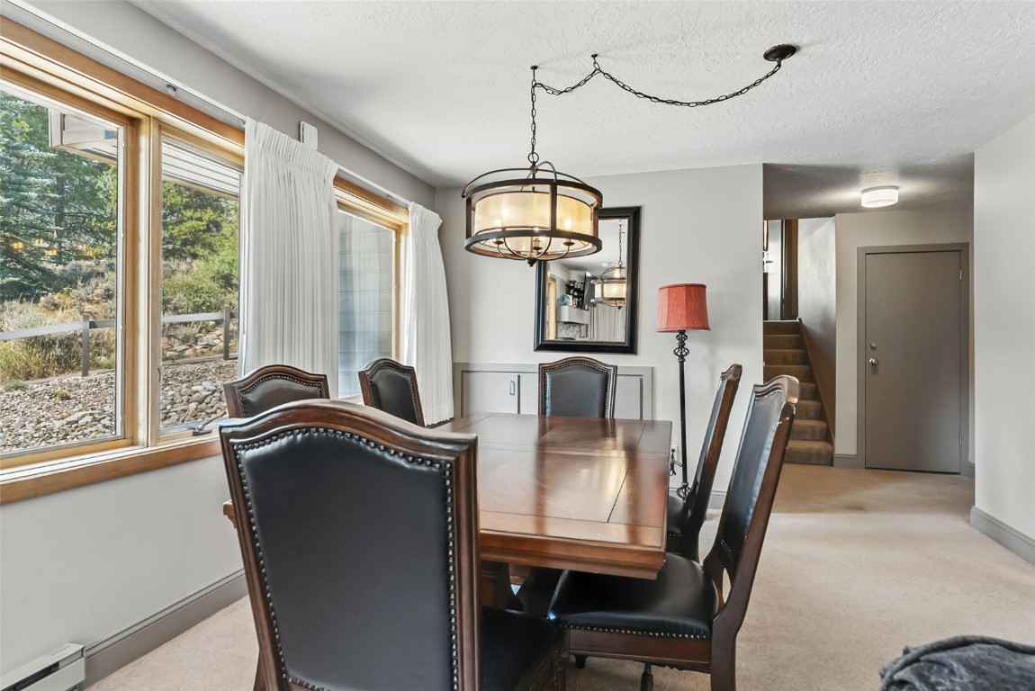 22300 Highway 6, Unit 1745 Keystone, CO 80435 - Photo 11 of 43 a dining room with furniture a chandelier and wooden floor