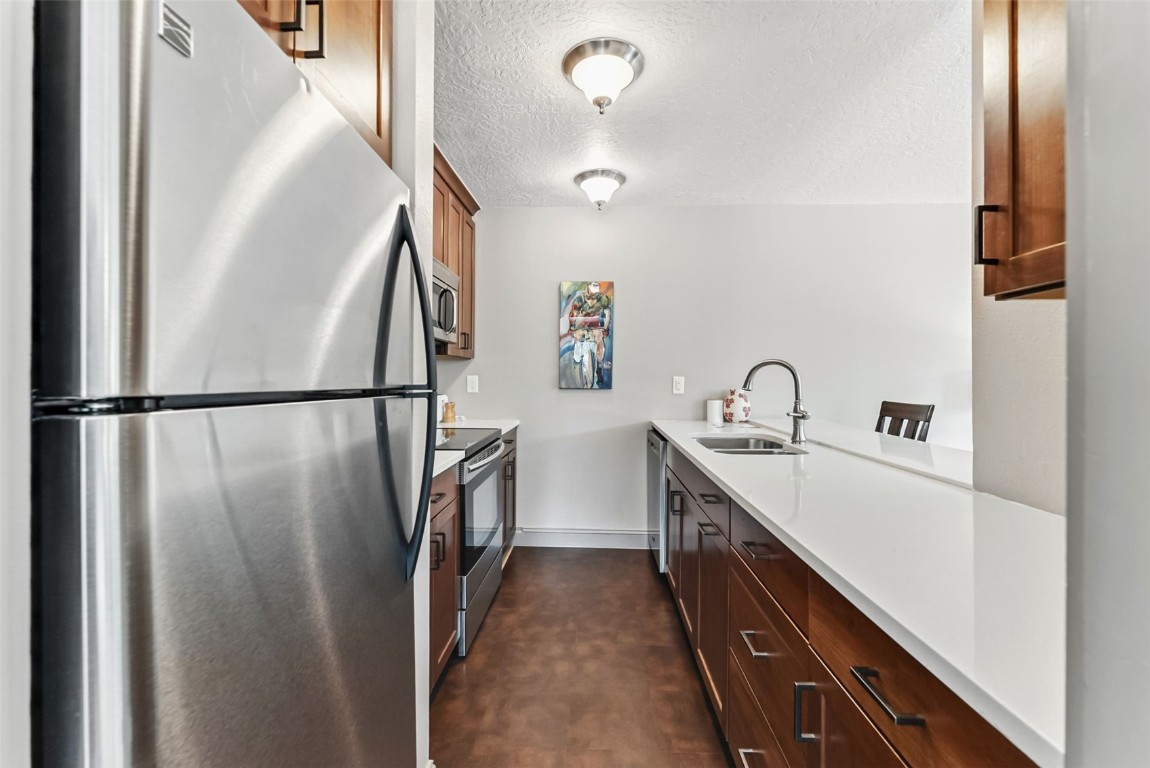 22300 Highway 6, Unit 1745 Keystone, CO 80435 - Photo 14 of 43 a kitchen with sink a refrigerator and wooden floor