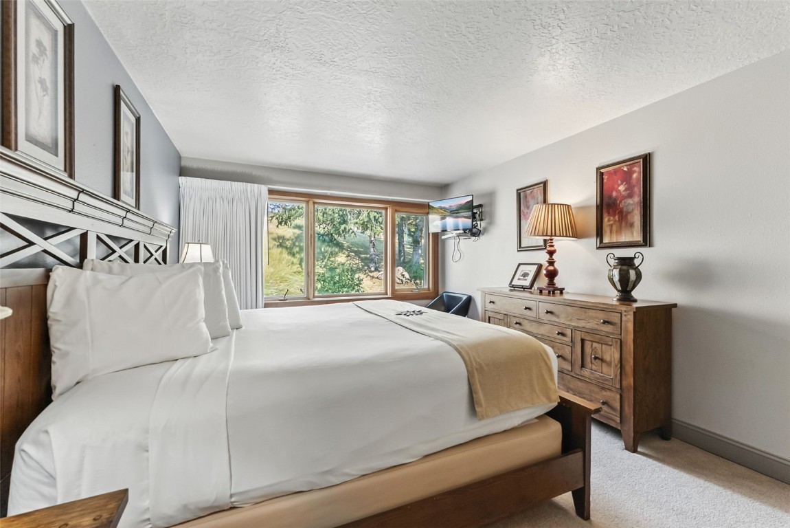 22300 Highway 6, Unit 1745 Keystone, CO 80435 - Photo 21 of 43 a bedroom with a bed and a flat tv screen on the dresser