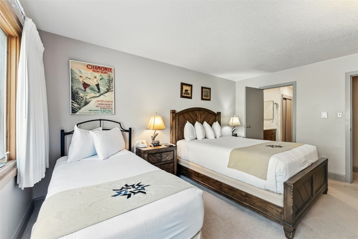 22300 Highway 6, Unit 1745 Keystone, CO 80435 - Photo 26 of 43 a bedroom with a large bed and paintings on the wall