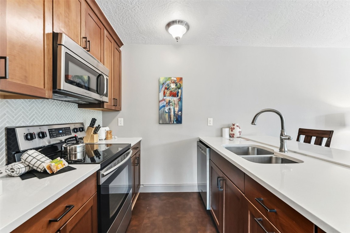 22300 Highway 6, Unit 1745 Keystone, CO 80435 - Photo 4 of 43 a kitchen with stainless steel appliances a sink a stove and a wooden floor
