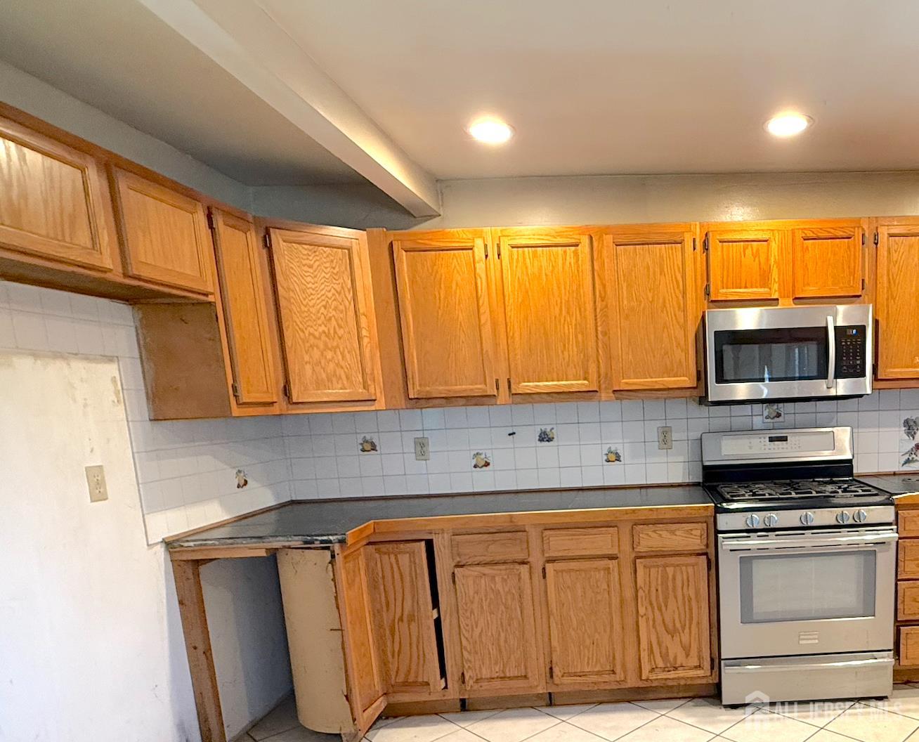 4 Forrestal Road Kendall Park, NJ 08824 - Photo 12 of 22 a kitchen with stainless steel appliances granite countertop a stove a sink and a microwave