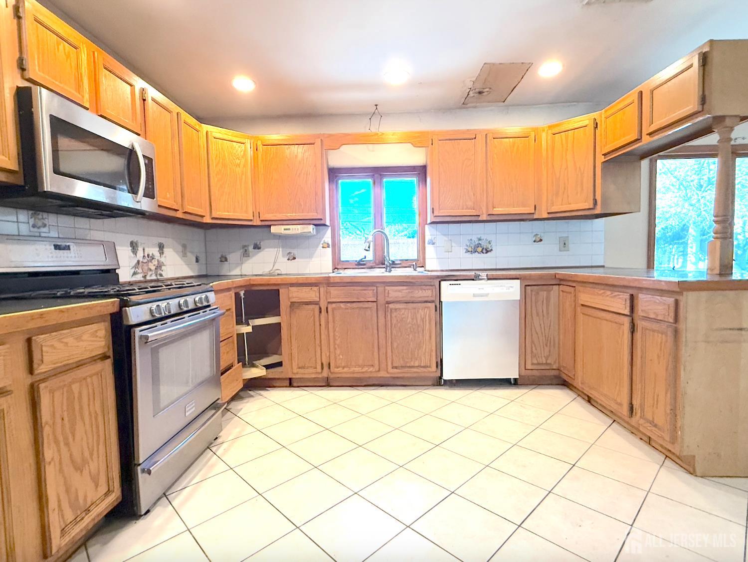 4 Forrestal Road Kendall Park, NJ 08824 - Photo 13 of 22 a kitchen with stainless steel appliances granite countertop a stove a sink and a microwave