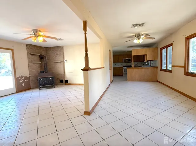 a view of a kitchen with kitchen island granite countertop a refrigerator and a stove top oven