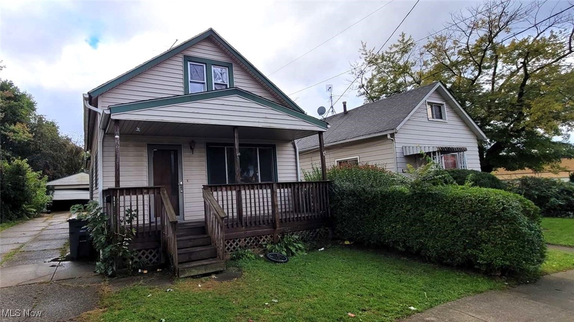 6816 Rathbun Avenue Cleveland, OH 44105 - Photo 1 of 10 Bungalow-style home featuring covered porch, a front yard, and a garage