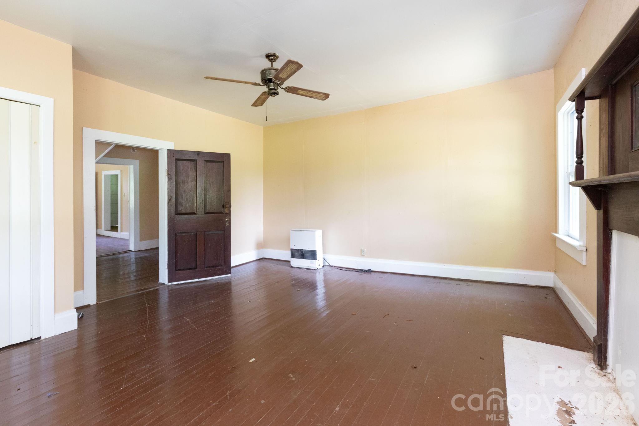 4085 Jacks Creek Road Burnsville, NC 28714 - Photo 10 of 24 a view of a livingroom with wooden floor and a ceiling fan