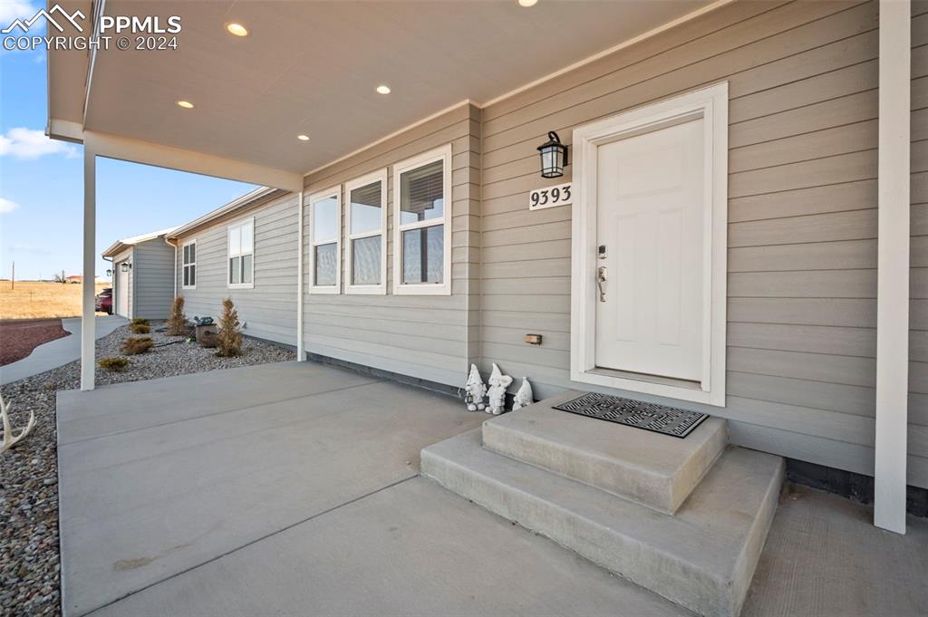 9393 North Log Road Calhan, CO 80808 - Photo 4 of 49 a view of a hallway with a couch and chandelier