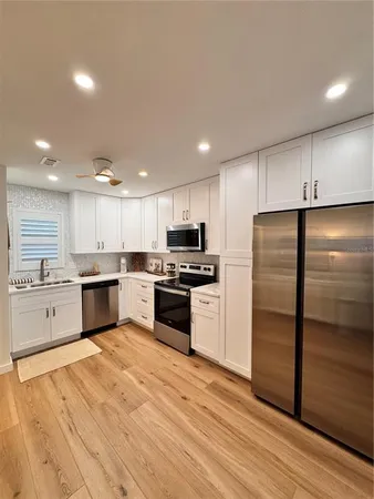 a kitchen with a refrigerator and a stove top oven