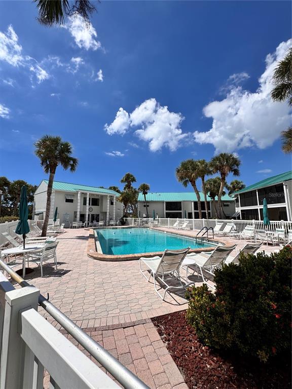 5623 Midnight Pass Road, Unit 615 Siesta Key, FL 34242 - Photo 19 of 21 a view of a house with backyard water fountain and a fire pit