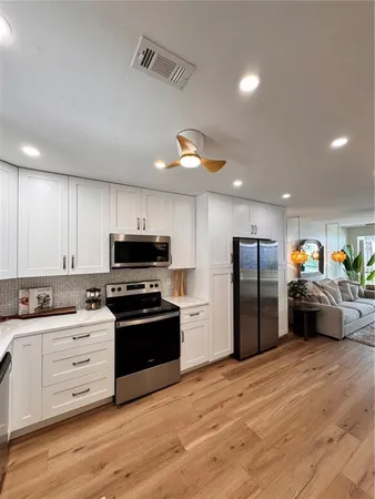 a kitchen with stainless steel appliances kitchen island granite countertop a refrigerator and a stove