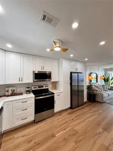 a kitchen with stainless steel appliances kitchen island granite countertop a refrigerator and a stove
