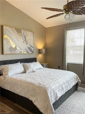 a bedroom with a bed and a painting on the wall