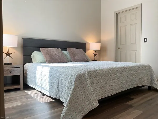 a bedroom with a bed and wooden floor