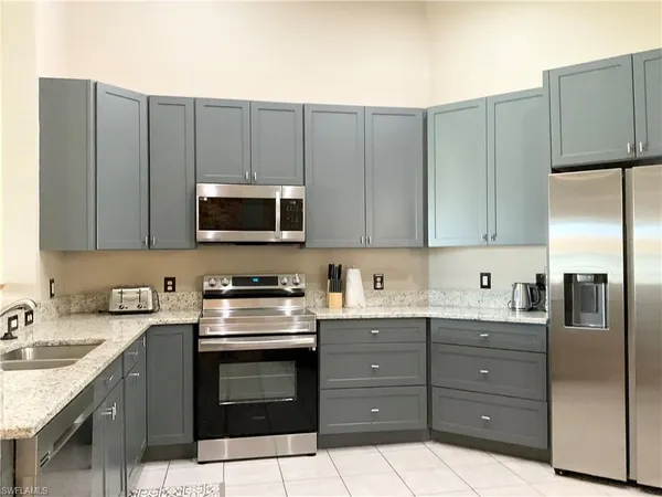 a kitchen with stainless steel appliances granite countertop a refrigerator and a stove top oven